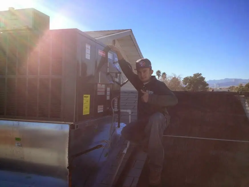 HVAC technician performing AC Tune-Up on a rooftop unit in Spanish Lake